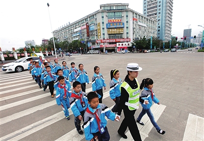 交警护送小学生过马路.